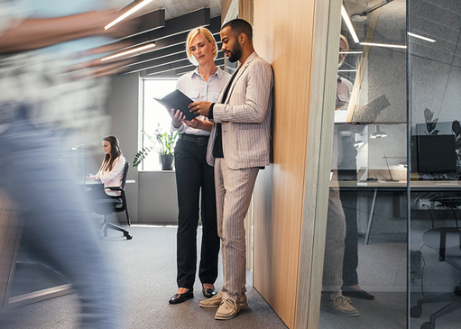 Eine Frau und ein Mann besprechen im Büro Notizen