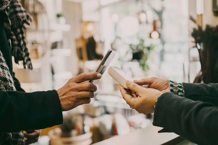 Kunde bezahlt in einem Geschäft seinen Einkauf mit dem Smartphone