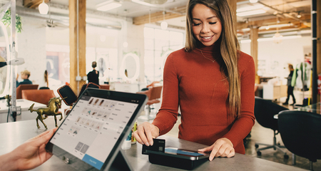 Kunde zahlt an einem POS-Terminal in einem Geschäft mit Karte