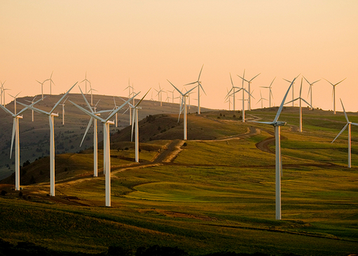 Windräder erzeugen Windenergie in einer hügeligen Landschaft