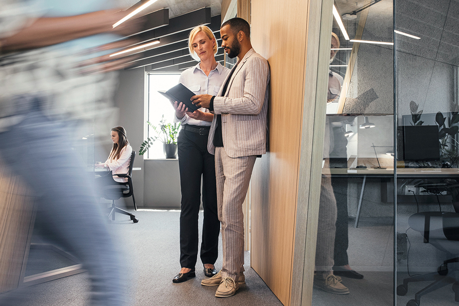 Eine Frau und ein Mann besprechen im Büro Notizen