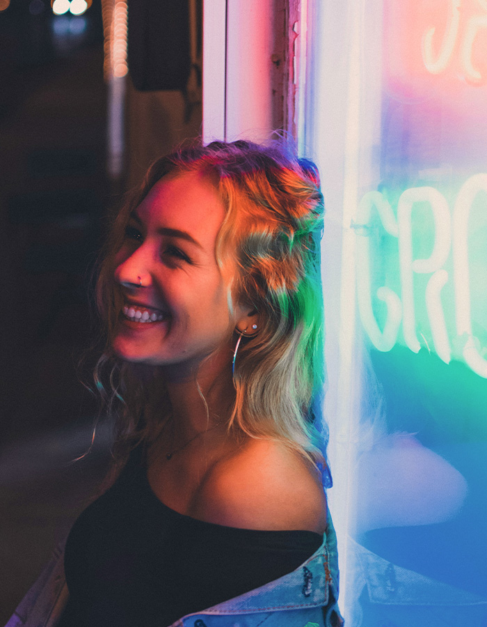 Lächelnde Frau mit Neon-Schriftzug