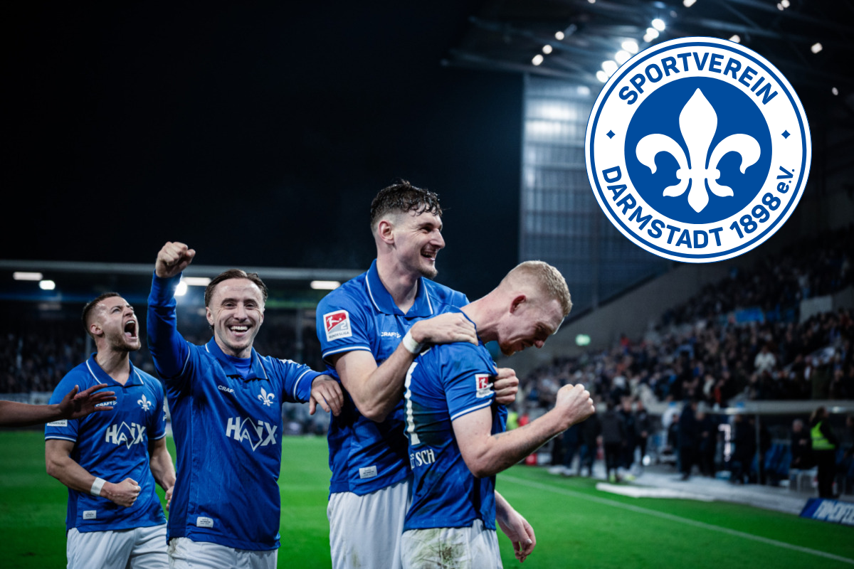 Jubelnde Spieler des SV Darmstadt 98 feiern nach einem Fußballspiel im Stadion; oben rechts ist das Vereinslogo eingeblendet.